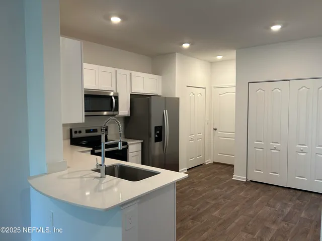 a kitchen with stainless steel appliances a refrigerator sink and microwave