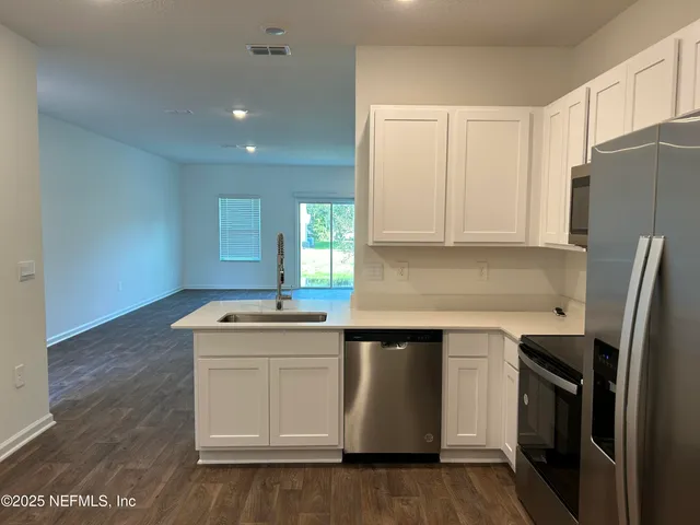 a kitchen with stainless steel appliances a sink stove and refrigerator