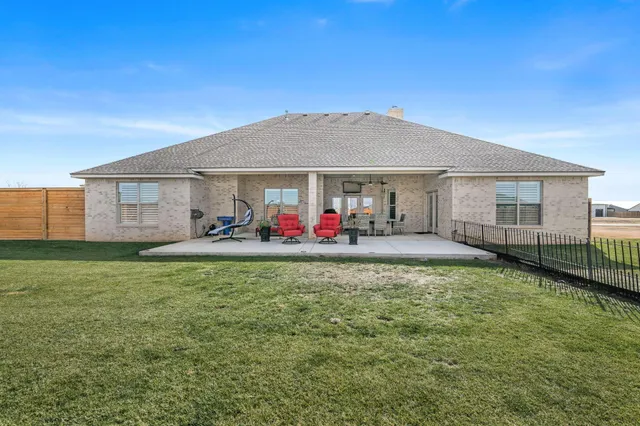 a backyard of a house with table and chairs