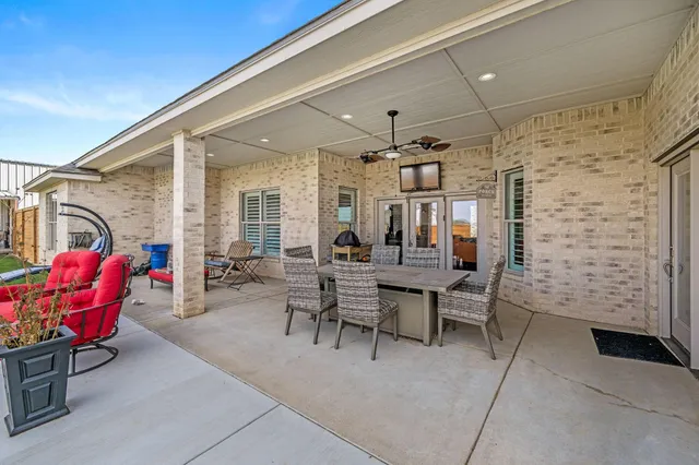 a view of a patio with dining table and chairs