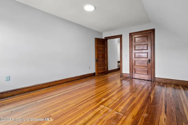a view of empty room with wooden floor