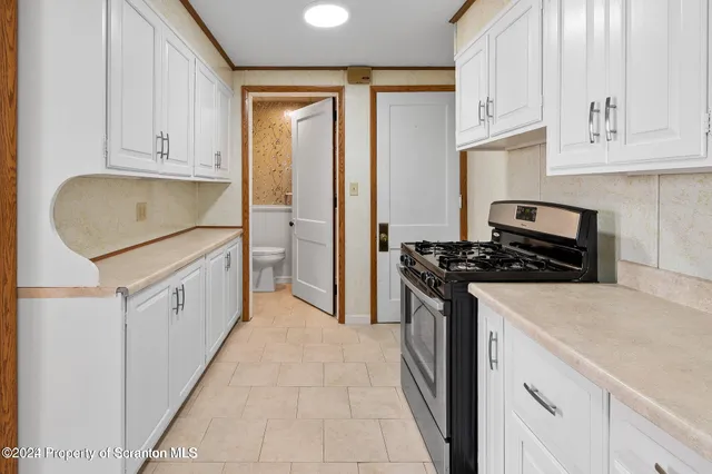 a kitchen with stainless steel appliances granite countertop white cabinets and a stove