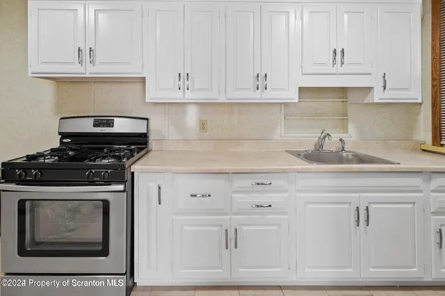 a kitchen with white cabinets and appliances