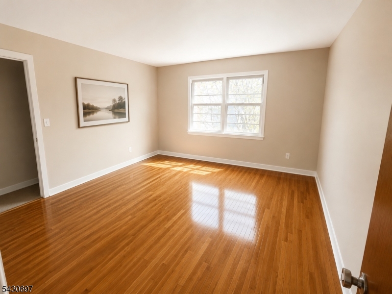 2479 Dayton Avenue Union, NJ 07083 - Photo 5 of 9 a view of an empty room with wooden floor and a window