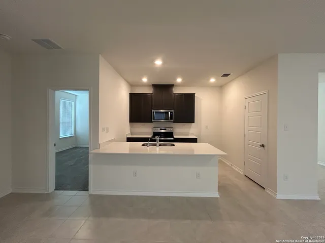 a view of kitchen with kitchen island a sink and a stove