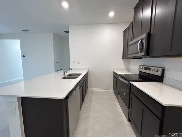 a kitchen with stainless steel appliances a sink and a refrigerator