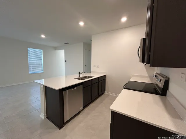 a kitchen with a sink a counter top space and cabinets