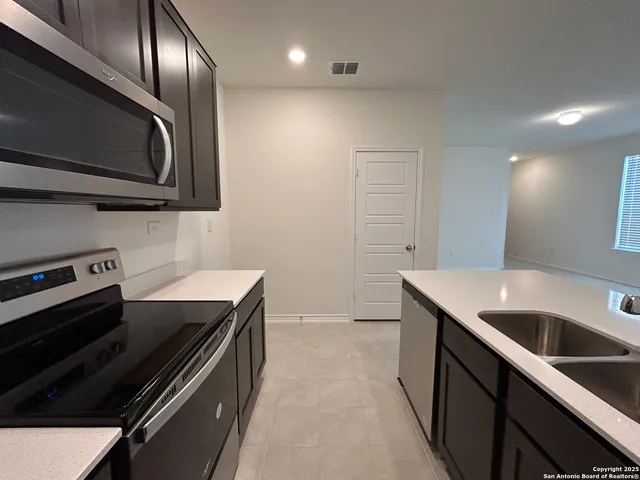 a kitchen with a sink and stainless steel appliances