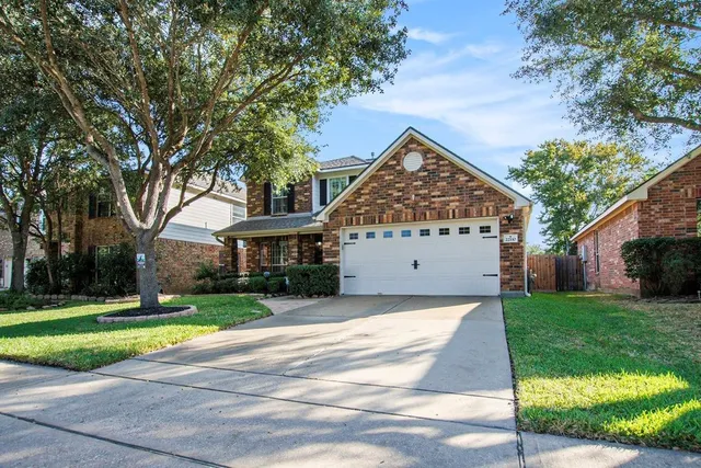 a front view of a house with a yard and trees