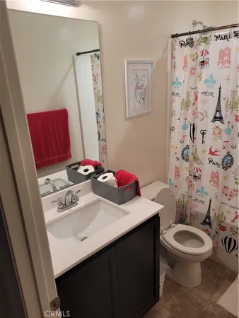 a bathroom with a sink a toilet and shower curtain