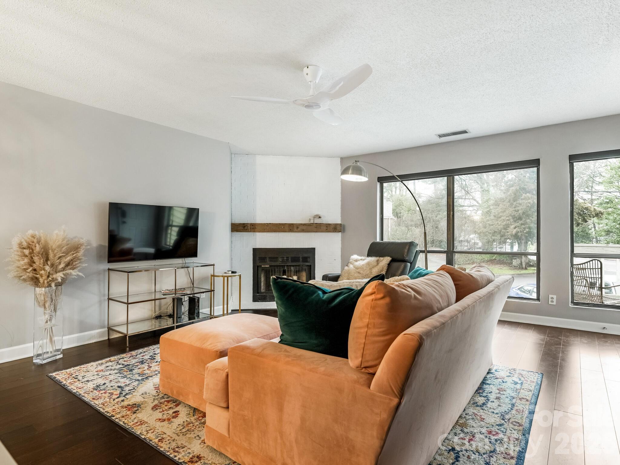 1612 Sharon Road West, Unit 68 Charlotte, NC 28210 - Photo 3 of 18 a living room with fireplace furniture and a flat screen tv