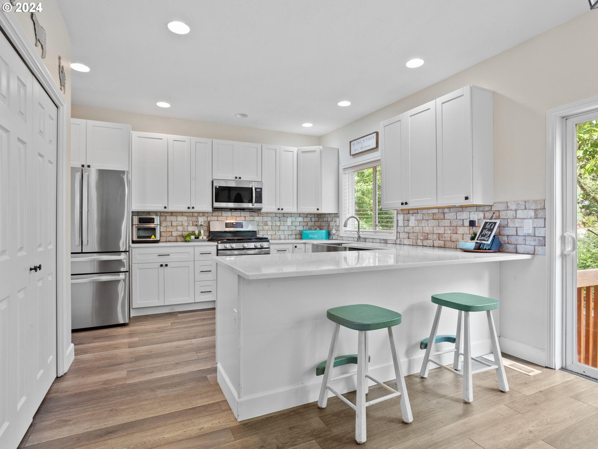 17156 Southeast Macanudo Street Damascus, OR 97089 - Photo 13 of 47 a kitchen with granite countertop white cabinets refrigerator and chairs