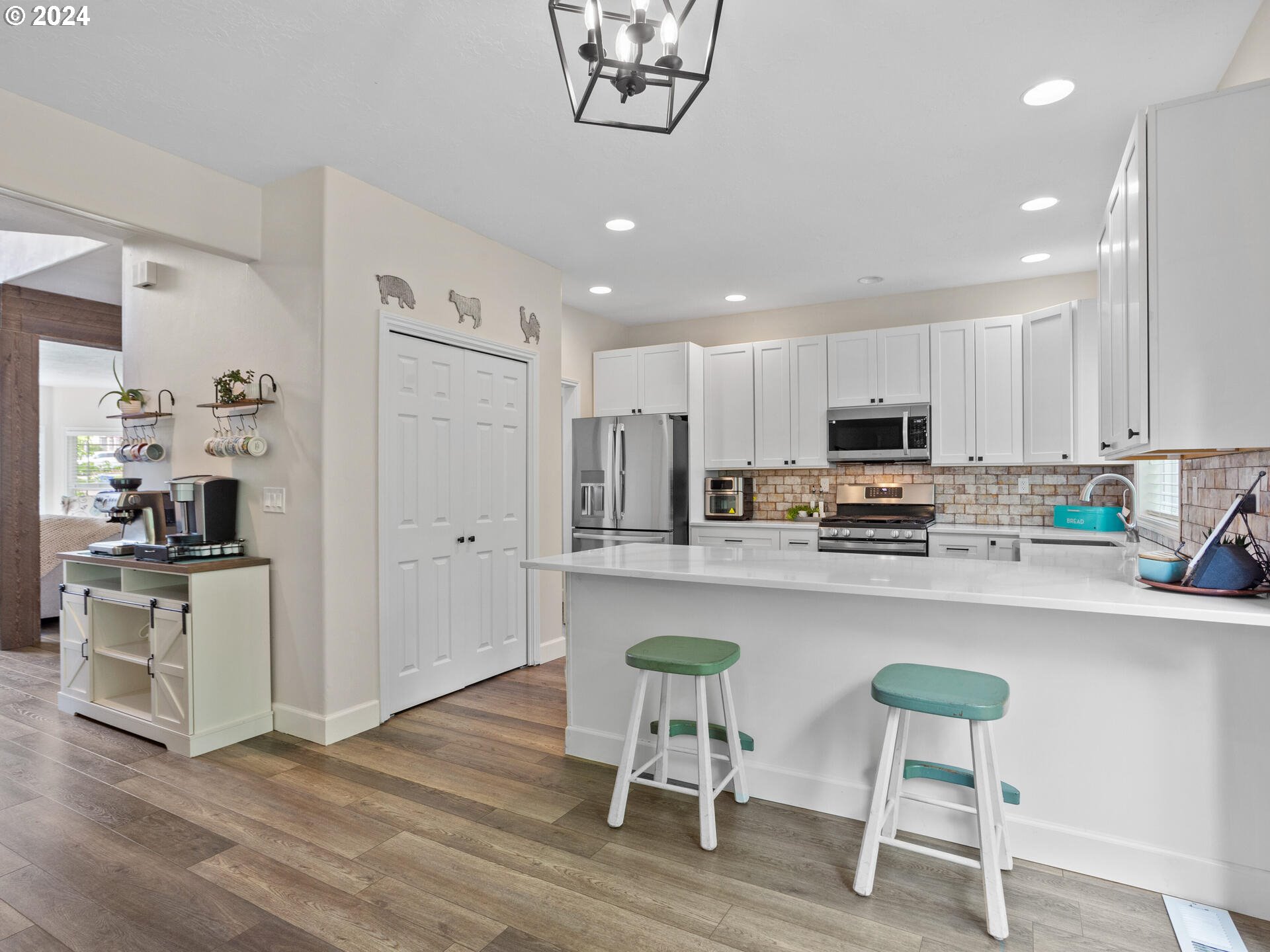 17156 Southeast Macanudo Street Damascus, OR 97089 - Photo 14 of 47 a kitchen with stainless steel appliances granite countertop a table chairs refrigerator and microwave