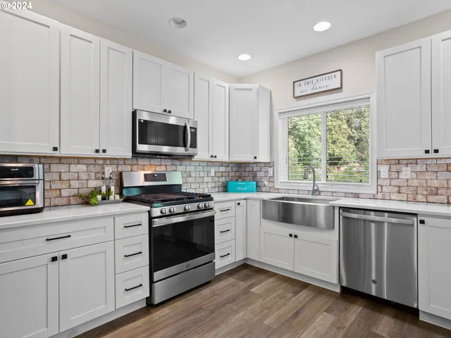 a kitchen with granite countertop white cabinets and white appliances