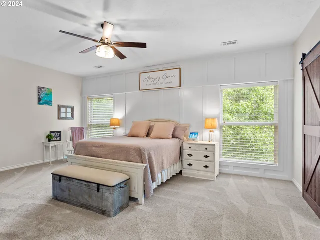 a spacious bedroom with a bed and a chandelier