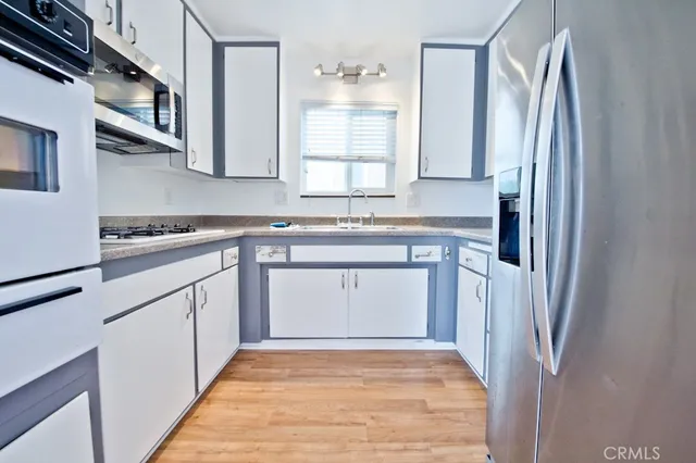 a kitchen with stainless steel appliances granite countertop a refrigerator and a stove