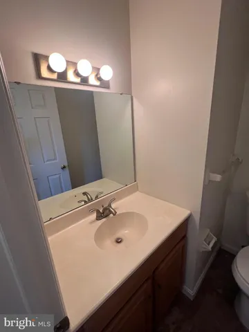 a bathroom with a sink vanity and toilet