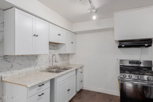 a kitchen with cabinets stainless steel appliances and a sink