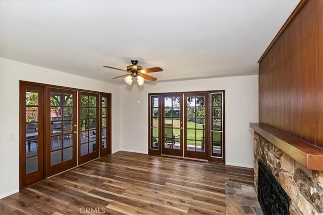 a view of an empty room with window and wooden floor