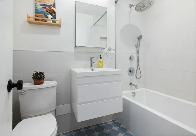 a bathroom with a sink a toilet and shower
