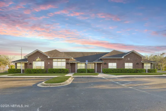a view of house with a big yard and potted plants
