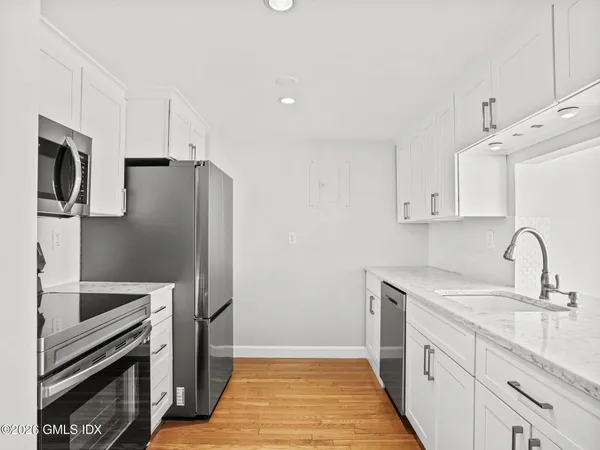 a kitchen with stainless steel appliances a refrigerator sink and microwave