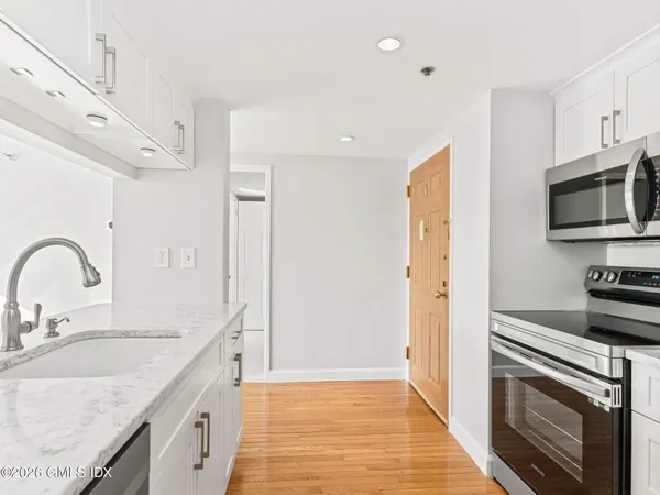a kitchen with stainless steel appliances granite countertop a sink a stove and a refrigerator