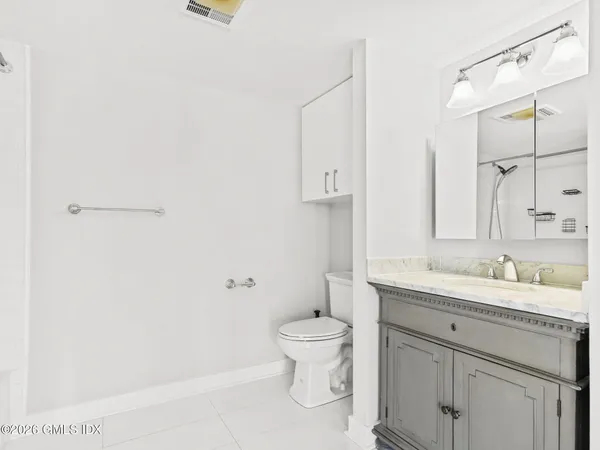 a bathroom with a granite countertop sink a toilet and a mirror