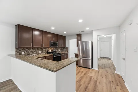 a kitchen with stainless steel appliances granite countertop a refrigerator and a stove