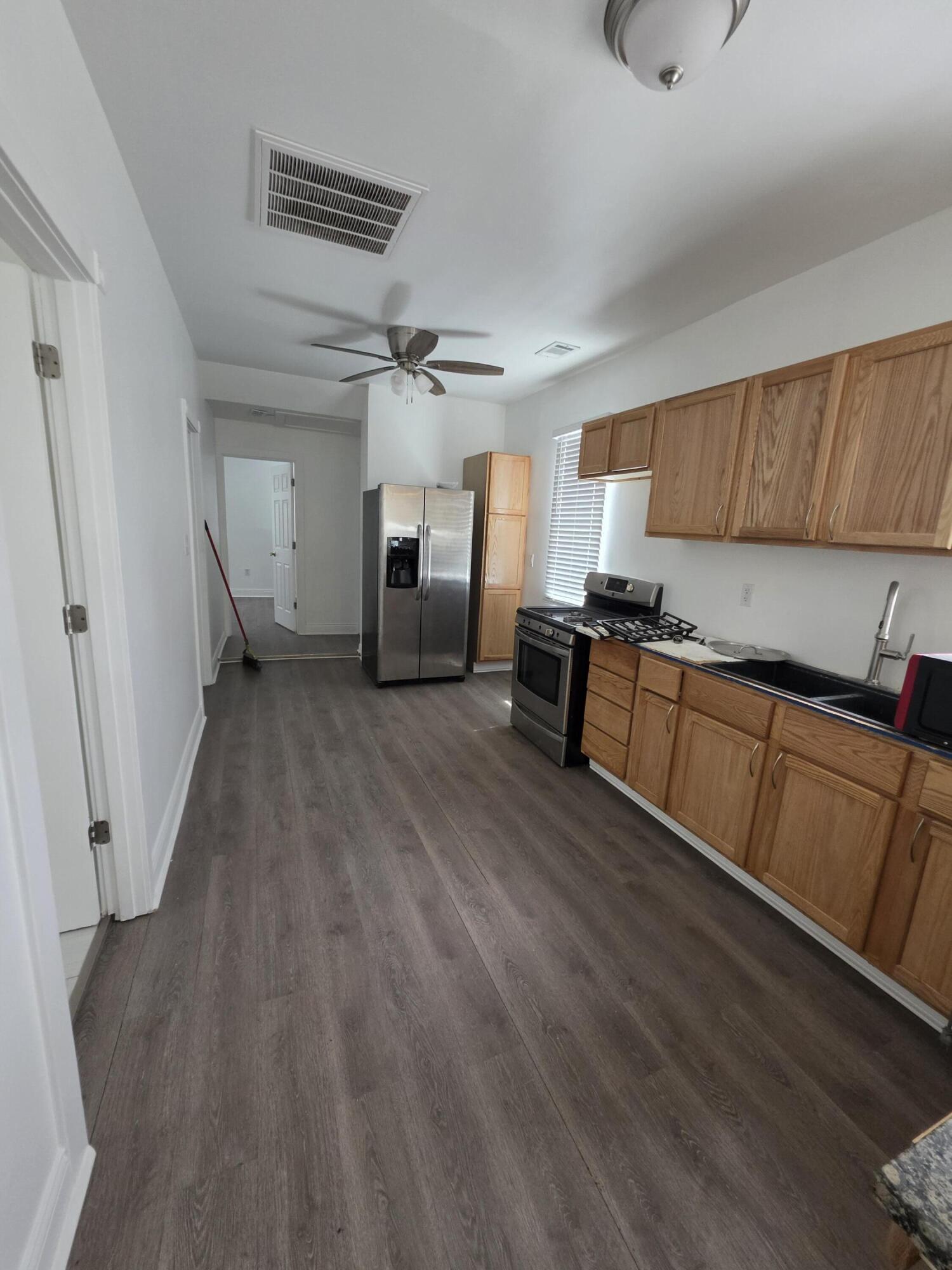 4149 Broadway Gary, IN 46409 - Photo 10 of 26 a kitchen with stainless steel appliances granite countertop a refrigerator a sink dishwasher a stove and white countertops with wooden floor