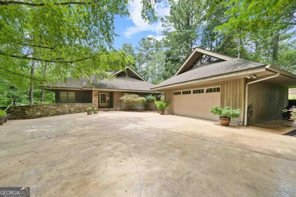 a view of a house with a yard and large tree