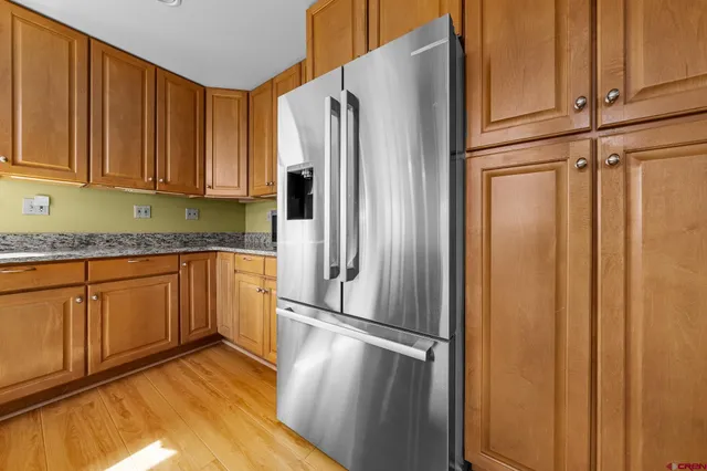 a kitchen with granite countertop stainless steel appliances a refrigerator and cabinets