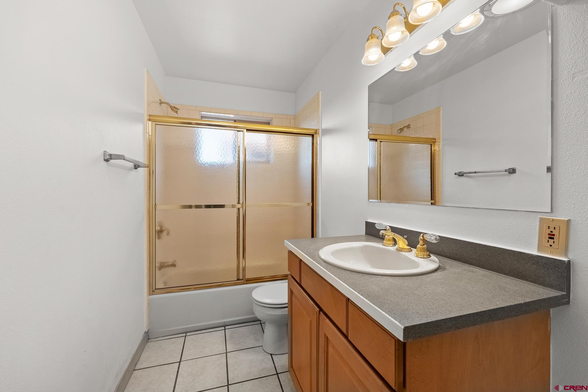 199 Logging Trail Road Durango, CO 81303 - Photo 24 of 33 a bathroom with a granite countertop sink a toilet and shower