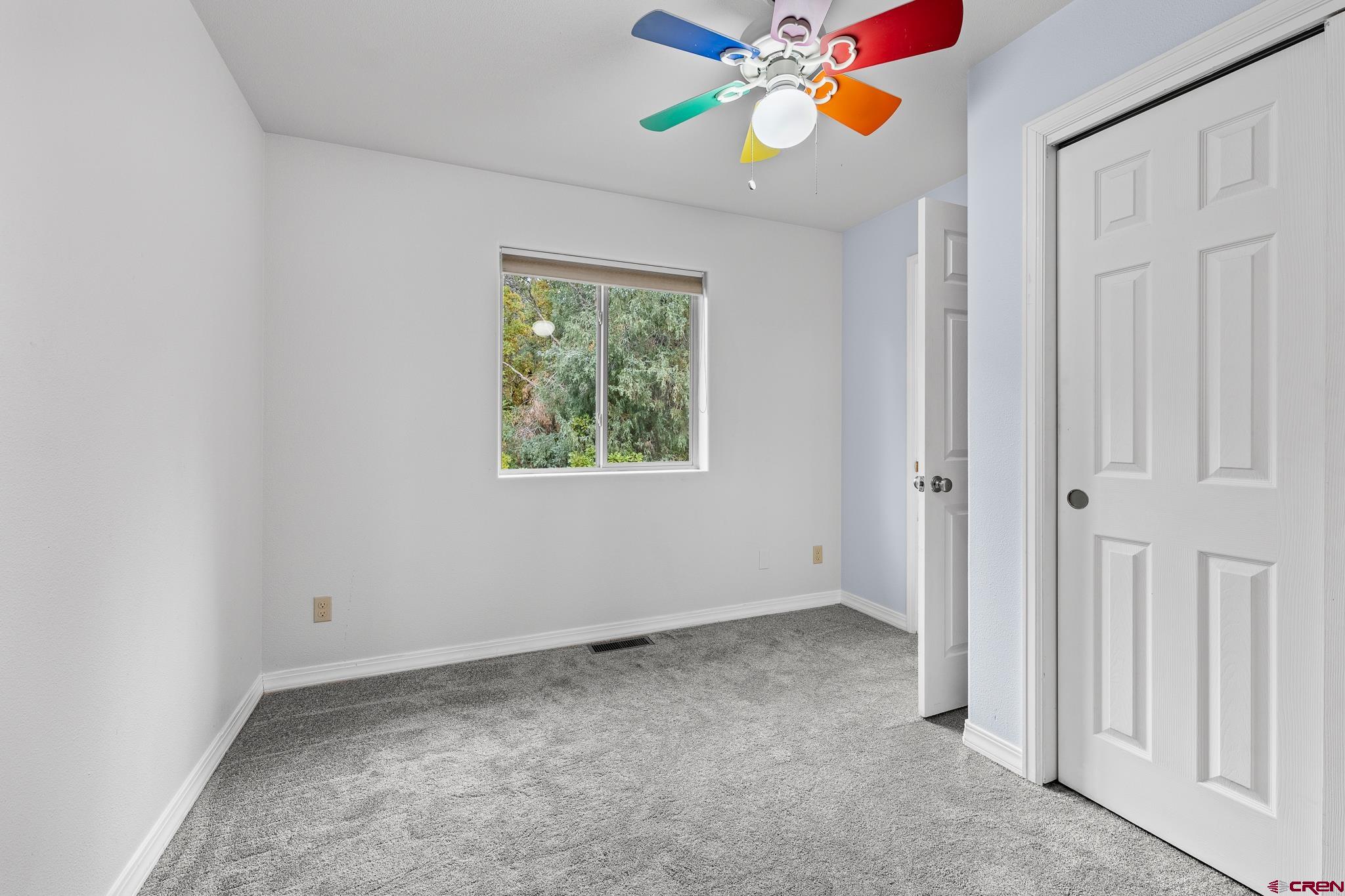 199 Logging Trail Road Durango, CO 81303 - Photo 27 of 33 an empty room with windows and ceiling fan