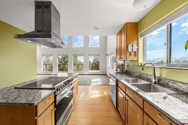a large kitchen with granite countertop a large window