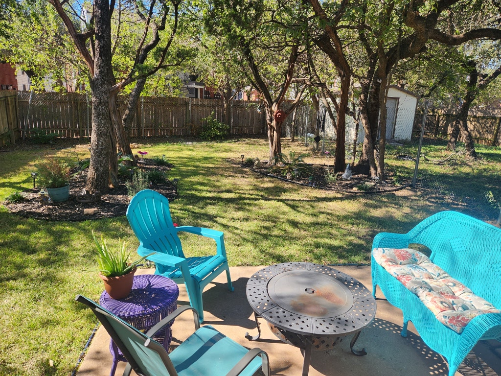12306 Cahone Trail, Unit A Austin, TX 78729 - Photo 11 of 25 a view of a backyard with table and chairs potted plants and large tree
