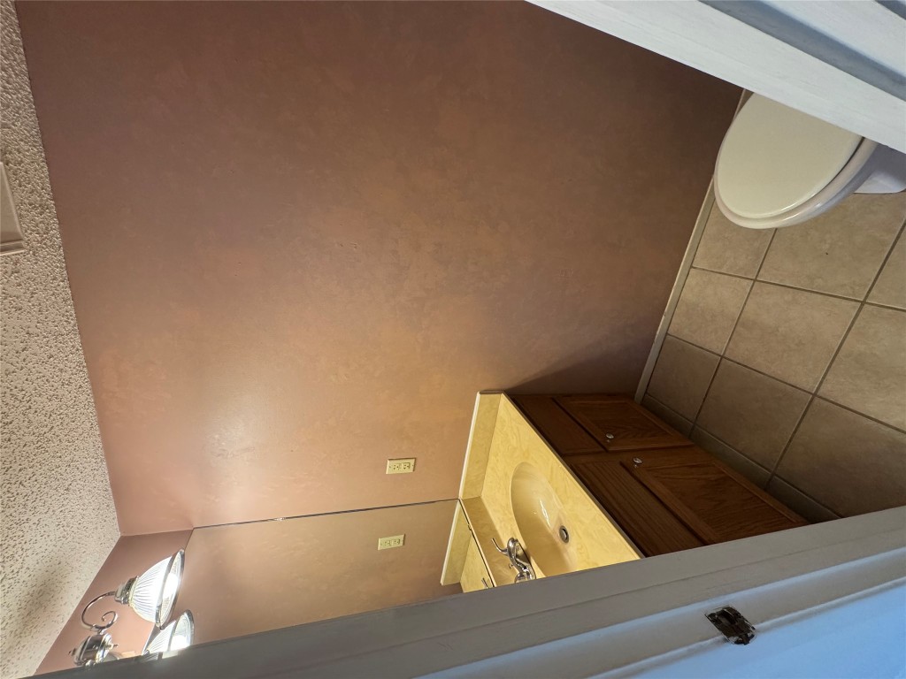 12306 Cahone Trail, Unit A Austin, TX 78729 - Photo 12 of 25 a bathroom with a sink a toilet and a mirror