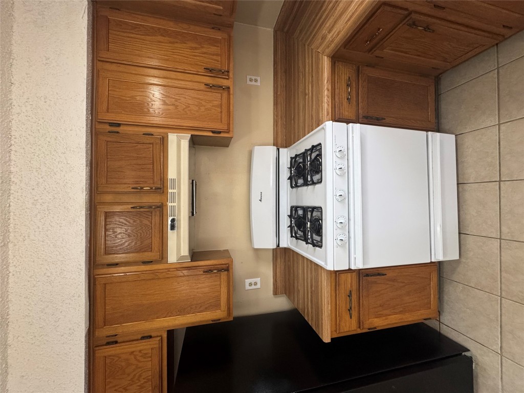 12306 Cahone Trail, Unit A Austin, TX 78729 - Photo 13 of 25 a white stove top oven sitting inside of a kitchen