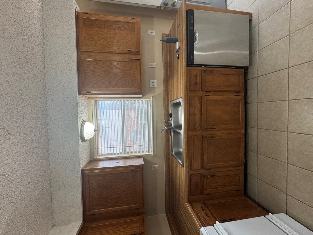 12306 Cahone Trail, Unit A Austin, TX 78729 - Photo 14 of 25 a kitchen with stainless steel appliances granite countertop a sink and a microwave