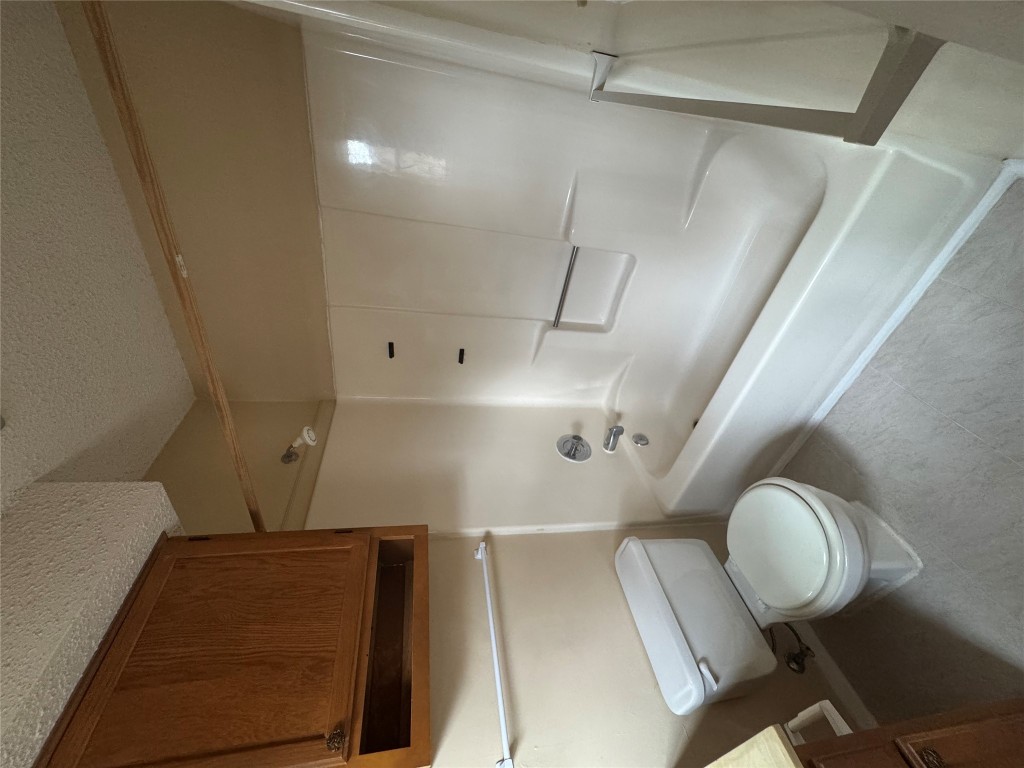 12306 Cahone Trail, Unit A Austin, TX 78729 - Photo 19 of 25 a bathroom with a toilet a sink and bathtub