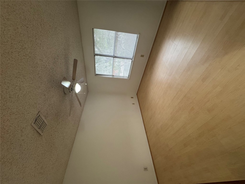 12306 Cahone Trail, Unit A Austin, TX 78729 - Photo 22 of 25 an empty room with windows and ceiling fan view