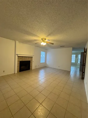 an empty room with windows and fireplace