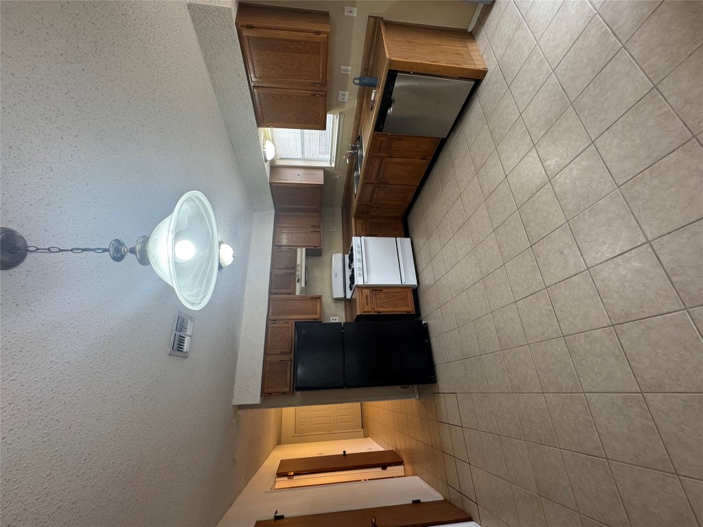 12306 Cahone Trail, Unit A Austin, TX 78729 - Photo 10 of 25 a large kitchen with cabinets and stainless steel appliances