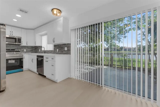 a kitchen with kitchen island stainless steel appliances a stove a sink and a refrigerator