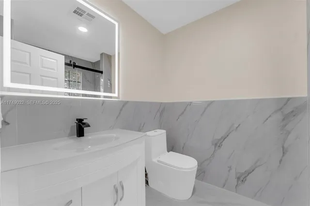 a bathroom with a sink a toilet and mirror