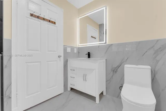 a white toilet sitting next to a bathroom sink