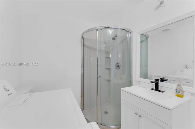 a bathroom with a sink a shower and mirror