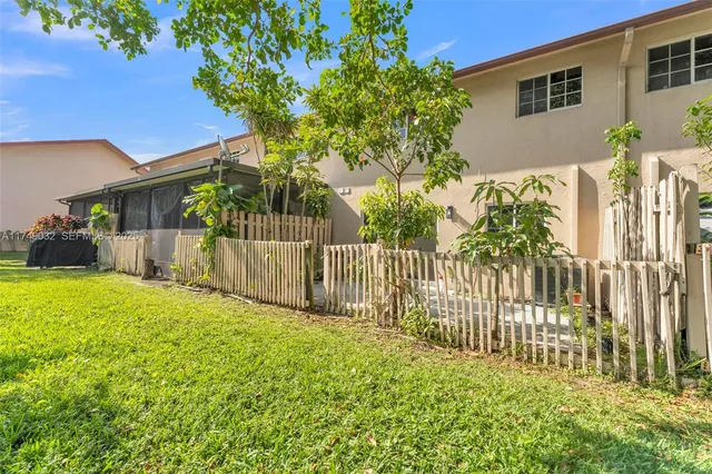 a view of a house with a small yard and wooden fence