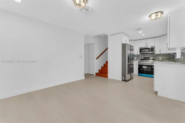 a view of a kitchen with a sink wooden floor and a window