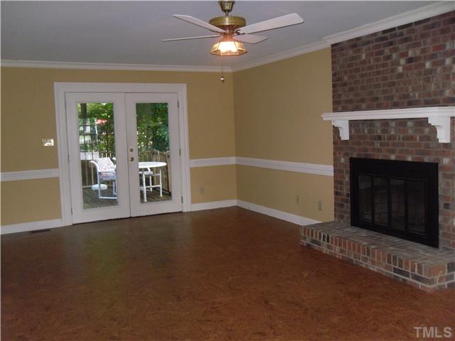 8716 Master Court Raleigh, NC 27615 - Photo 4 of 15 a view of an empty room with exposed radiator and fireplace
